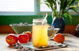 Question Does Apple Cider Vinegar Help With Weight Loss Represented by Mason Jar with ACV Surrounded by Apples on Table | Vitacost.com/blog