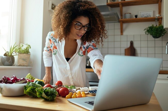 Homemade Meals The Benefits of Cooking at Home Woman Cooking at Home to Improve Health | Vitacost.com/Blog