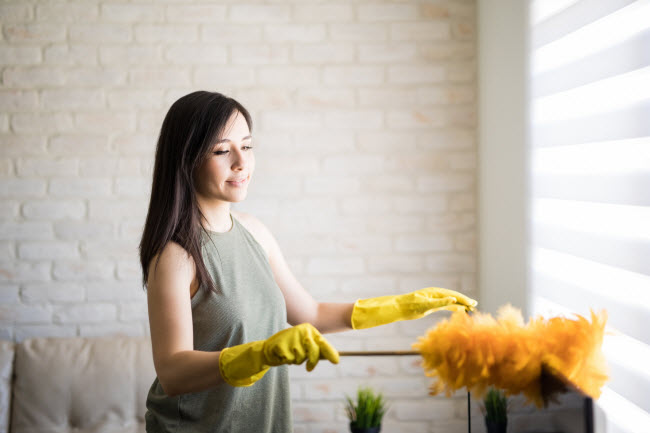 Woman in Yellow Gloves Following Cleaning Tips for Best Way to Dust Her Home | Vitacost.com/blog
