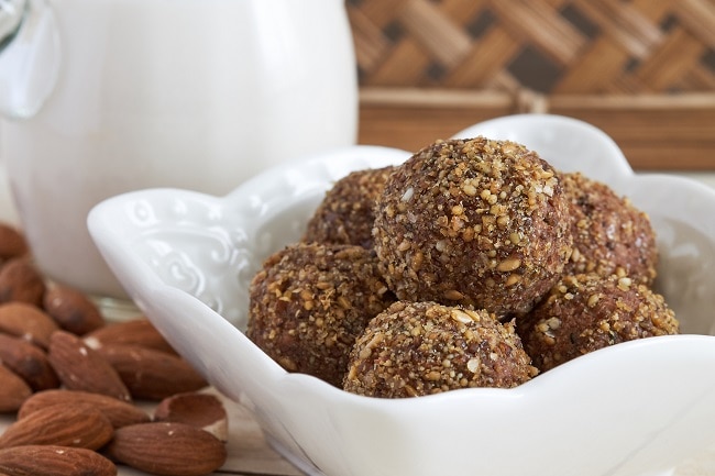 Chocolate Chip Collagen Protein Balls Collagen Protein Balls in White Bowl Surrounded by Almonds | Vitacost.com/blog