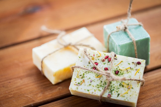 DIY Crafts Including Homemade Soaps Made With Dried Herbs & Spices Tied With Twine on Wooden Table | Vitacost.com/blog