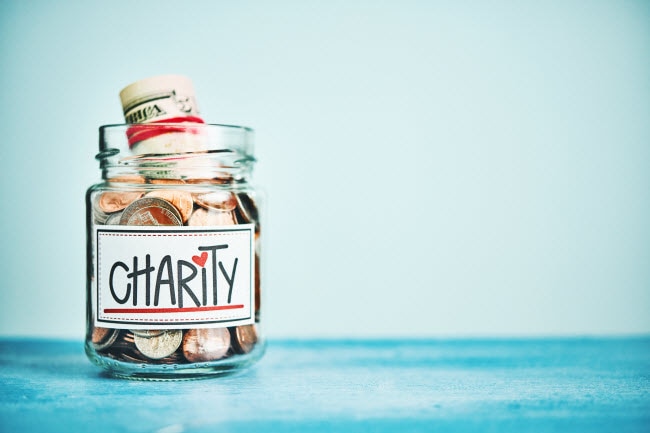 Giving is the New Getting: 3 Ways to Give Better  Example of Ways to Give: Coins and Cash Donations Stuffed in Charity Jar on Blue Table | Vitacost.com/blog