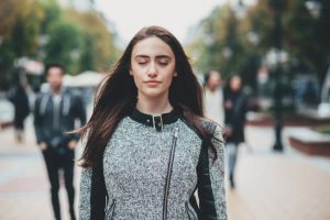 Young Brunette Woman in Workout Gear With Eyes Closed Learning How to Breathe Properly During Exercise | Vitacost.com/blog