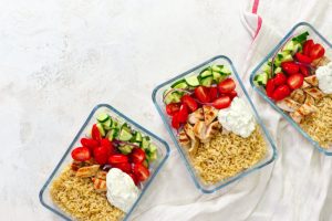 Three Glass Storage Containers with Rice, Veggies and Chicken on White Table Prepped by Someone Who Learned How to Use a Slow Cooker