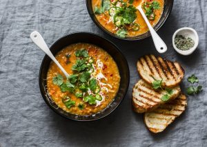 Red Lentil Soup in Black Bowls with Slices of Toasted Bread | Vitacost.com/blog