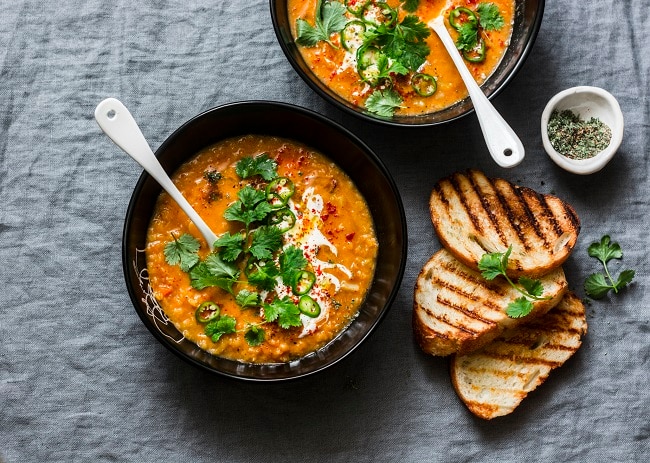 Red Lentil Soup in Black Bowls with Slices of Toasted Bread | Vitacost.com/blog