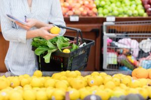 Torso view of Woman Learning How to Shop Healthy Browsing Lemons in Supermarket Produce Aisle | Vitacost.com/blog