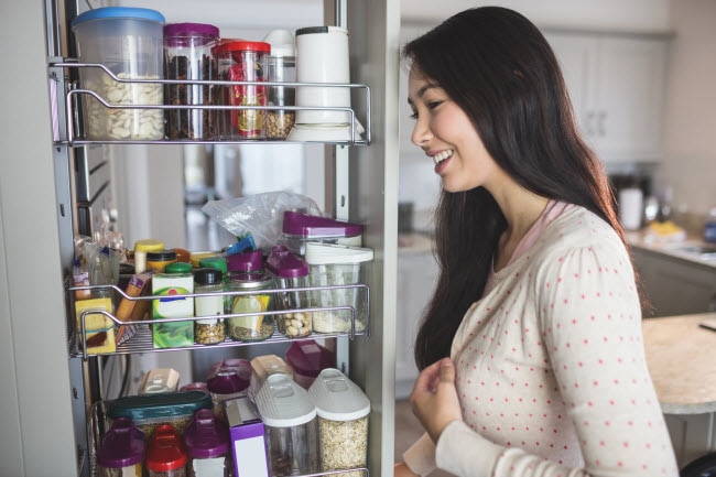Woman Who is Eating Gluten Free Browsing Pantry Shelves for Appropriate Items to Cook | Vitacost.com/blog