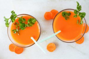 Overhead View of Two Glasses Filled With Carrot Juice on White Table as Example of Best Diet for Eye Health | Vitacost.com/blog
