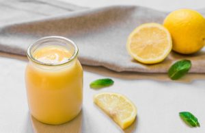 Vegan Lemon Curd in Small Glass Jar with Lemons on Wood | Vitacost.com/blog