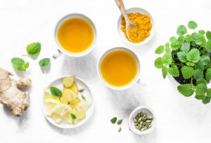 Different Types of Tea Including Ginger and Turmeric with Fresh Herbs and Lemon Slices on White Marble Surface | Vitacost.com/blog