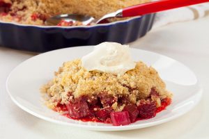 Gluten-Free Rhubarb Crumble of White Plate with Vegan Whipped Cream | Vitacost.com/blog