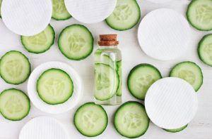 DIY Toner Made with Cucumbers Surrounded by Cucumber Slices and White Cotton Pads on White Table | Vitacost.com/blgog