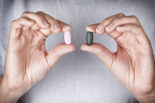 Close-up View of Two Hands Holding Prebiotics and Probtiocs Capsules | Vitacost.com/blog