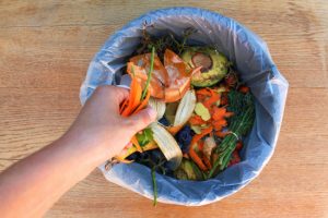 Woman Learning How to Stop Composting Tossing Leftover Food Scraps Into Trash Cans | Vitacost.com/blog