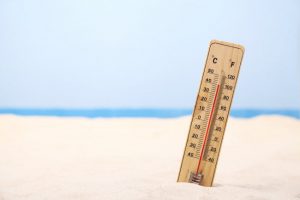 Wooden Thermometer in Sand at Beach to Represent Question What is the Difference Between Heat Exhaustion and Heat Stroke | Vitacost.com/blog