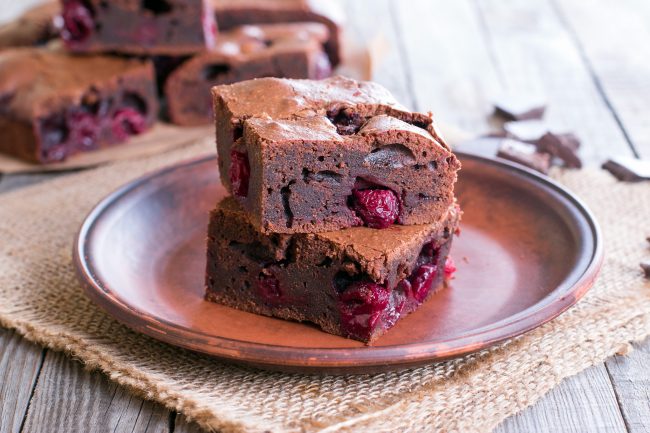 Chocolate-Cherry Brownies   Closeup of Brownie with Cherries on Brown Plate | Vitacost Blog