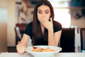 Woman Who Wants to Improve Gut Health Realizing Sh'e's Eating the Wrong Food at a Restaurant | Vitacost.com/blog