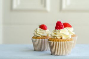 Three Tempting Vanilla Cupcakes with Buttercream Icing and Berries on To as Example of What to Enjoy on a Keto Cheat Day | Vitacost.com.blog