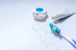 Concept of Oral Health and Dental Care Tips Represented by Toothbrush, Toothpaste & Floss on White Surface | Vitacost.com/blog