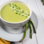 Green Soup with Asparagus in White Bowl next to Bread Sticks | Vitacost Blog
