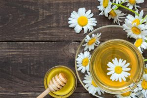 Overhead View of Cup of Chamomile Tea with Flowers and Honey on Wooden Table as Example of Foods That Help With Anxiety | Vitacost.com/blog