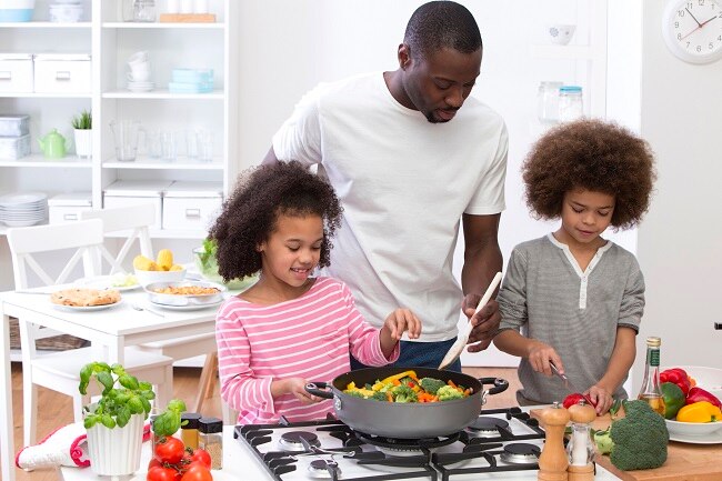 Father Cooks with Kids in Kitchen, Showing Health Habits in Place of Diets for Kids