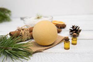 Orange-colored DIY pumpkin spice bath bomb on white wood