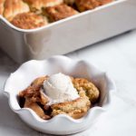 Bowl with Biscuit Apple Cobbler with Baking Dish in Background | Vitacost.com/blog