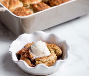 Bowl with Biscuit Apple Cobbler with Baking Dish in Background | Vitacost.com/blog