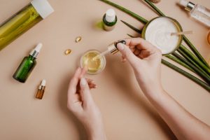 Overhead View of Woman's on Hands Dropping Essential Oil into Small Jar to Make DIY Headache Remedies | Vitacost.com/blog