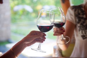 Friends at a Cafe Toasting Glasses to Celebrate Red Wine Health Benefits | Vitacost.com/blog
