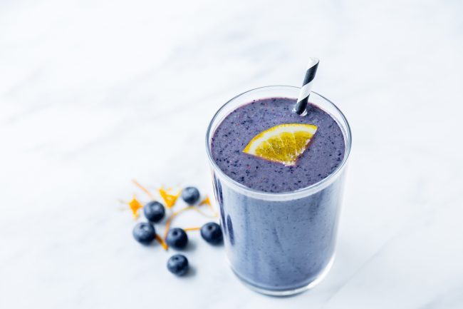 Blue Smoothie With Orange Slice Garnish in Clear Glass on White Marble |  Vitacost Blog