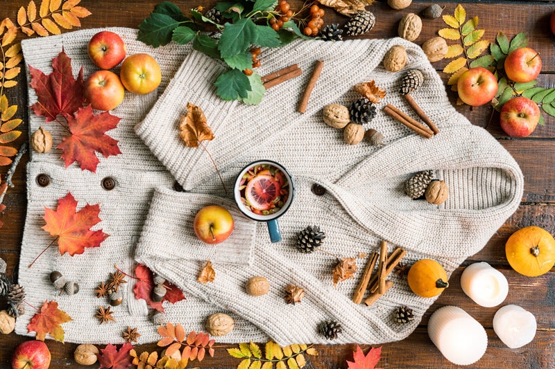 Concept of Fall Scents Represented by Scenic Shot of Apples, Leaves, Pinecones, Cinnamon and Sweater on Wood Table | Vitacost.com/blog
