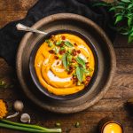 Smoked sweet potato soup in wooden bowl
