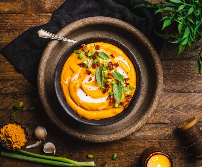 Smoked sweet potato soup in wooden bowl