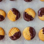 Shortbread Cookies Dipped in Chocolate on Parchment Covered Baking Sheet | Vitacost Blog