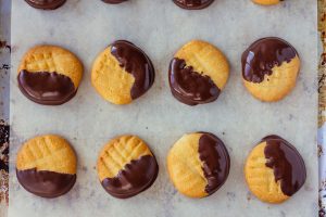 Shortbread Cookies Dipped in Chocolate on Parchment Covered Baking Sheet | Vitacost Blog