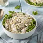 Angled Close Up of Chicken Salad in White Bowl on Blue Wooden Table | Vitacost Blog