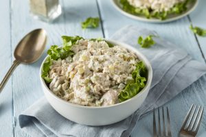 Angled Close Up of Chicken Salad in White Bowl on Blue Wooden Table | Vitacost Blog