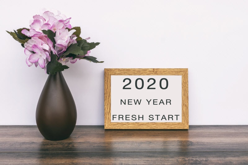 Framed Inspiration Quote and Vase of Flowers on Wooden Table to Represent Concept of Common New Year's Resolutions | Vitacost.com/blog