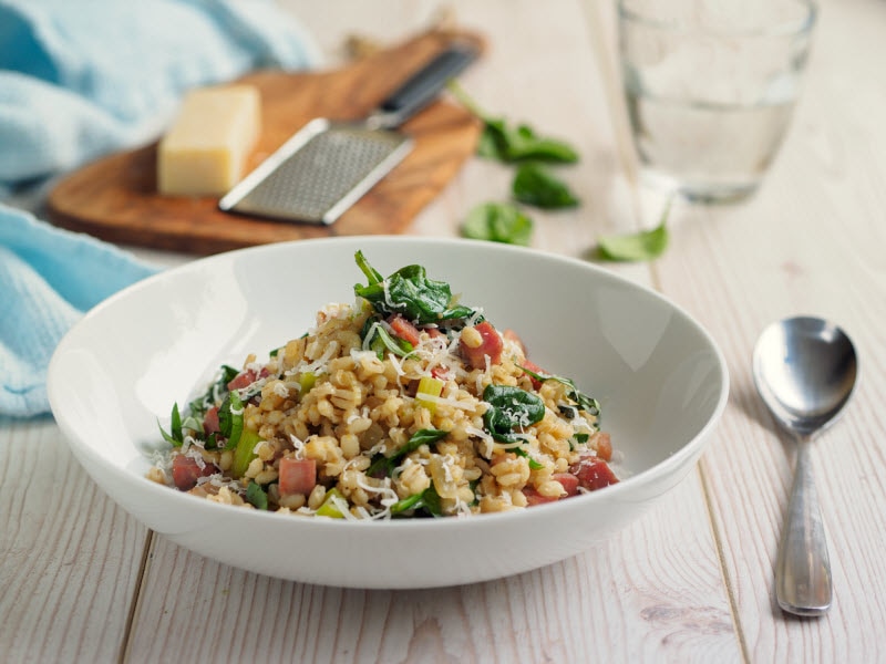 Barley Nutrition Represented by Bowl of Barley and Vegetable Risotto on White Wooden Table | Vitacost.com/blog
