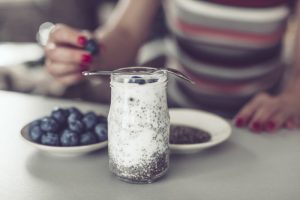 Woman Who Learned How to Use Protein Powder Adding Blueberries to Jar of Chia Seed Protein Pudding | Vitacost.com/blog