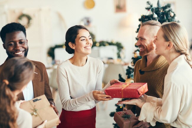 Smiling Family Members Exchanging Gifts at Christmas to Represent the Concept of Surviving the Holidays and Holiday Stress | Vitacost.com/blog