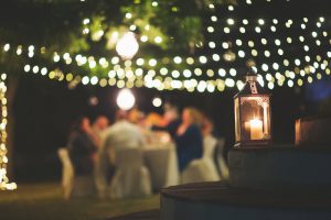 The Art of Gathering Being Enjoyed by Friends Dining Together on Patio Decorated with Twinkling Lights and Candles | Vitacost.com/blog