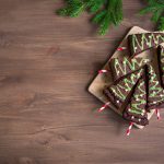 Top View of Christmas Tree Cake Pops with Green Frosting on Cutting Board and Wooden Background | Vitacost Blog
