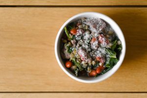 bowl of turkey sausage and kale soup on wooden table