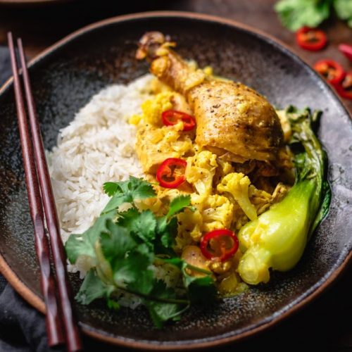 Close Up of Curried Chicken and Bok Choy Next to White Rice