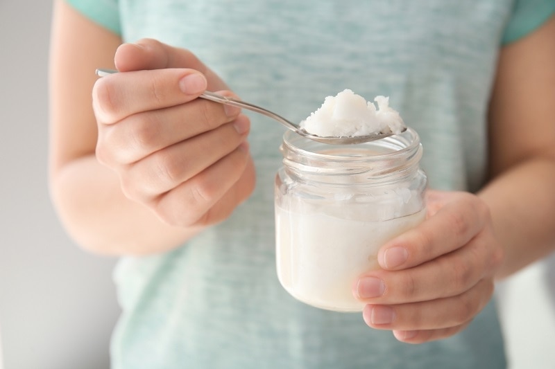 Woman Holding Coconut Oil in Spoon Before Oil Pulling | Vitacost.com/Blog