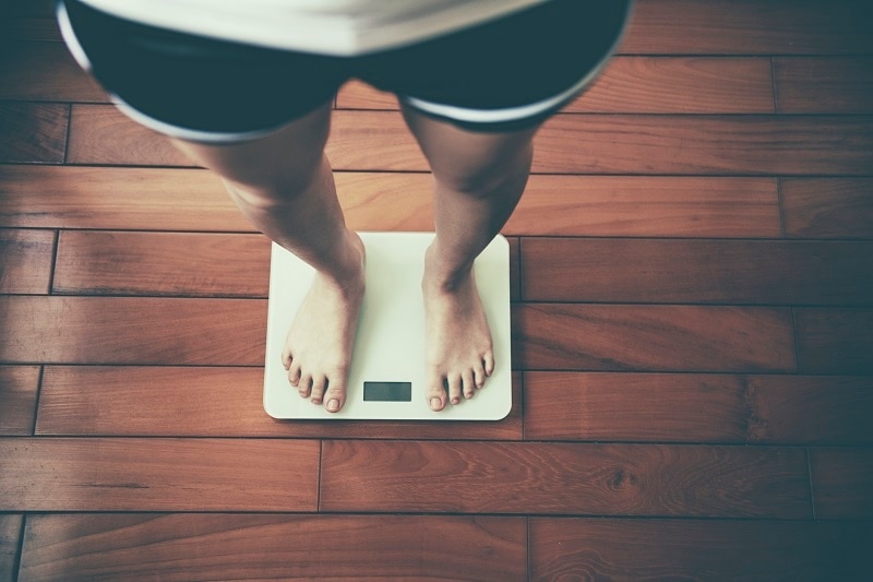 Woman Standing on Scale to Check for Healthy Weight | Vitacost.com/Blog
